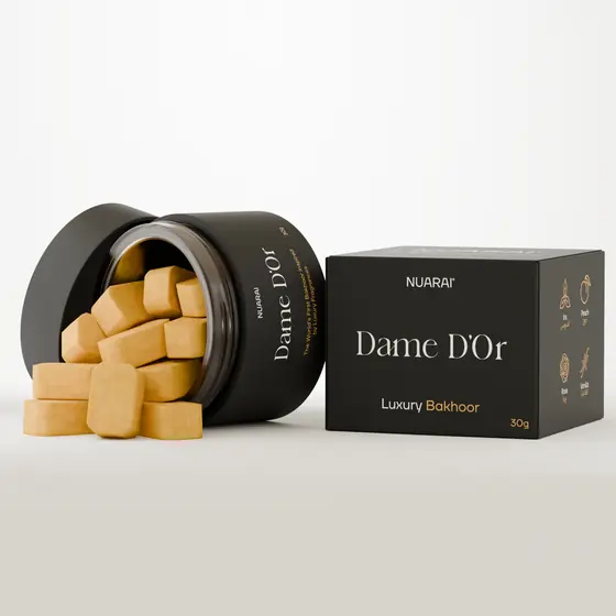Pot de bakhoor Dame D'Or Nuarai renversé à côté de sa boîte, rendu 3D par Mira Visions