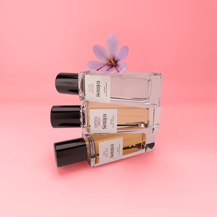 Vignette de la collection parfums cheveux Seraya, trois flacons de 50 ml empilés sur fond rose avec une fleur de safran