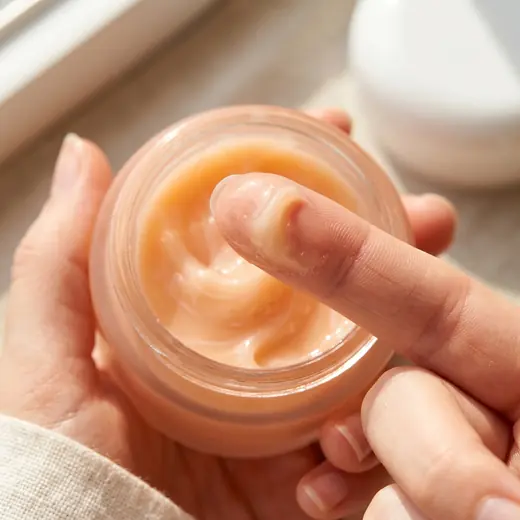 Turapura cream jar opened with a finger taking product, content by Mira Visions
